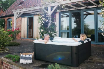 A couple enjoying the convenience of MSpa Oslo inflatable hot tub on their house porch.