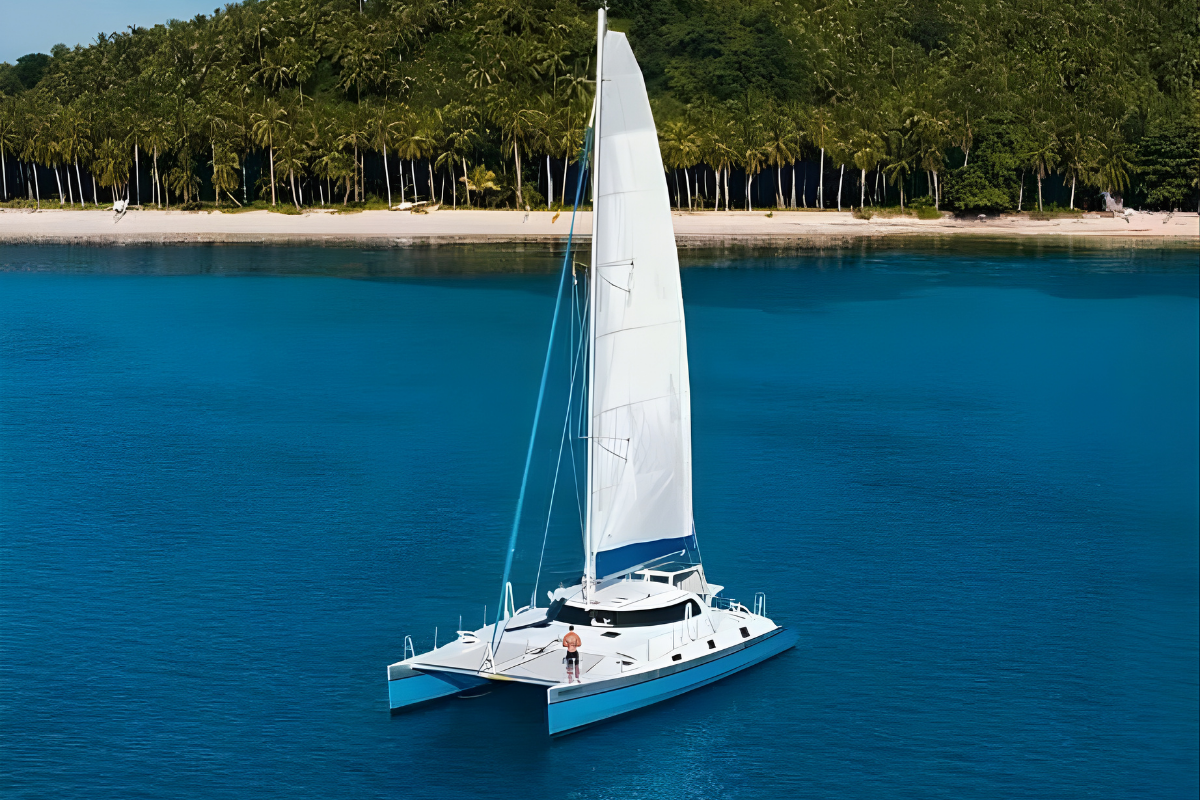 Luxury Moonpath Catamaran yacht sailing in Siargao’s turquoise waters under clear blue skies.